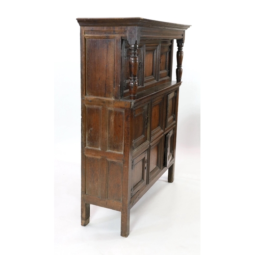 208 - A mid 18th century oak cupboard, with moulded cornice and three central dummy panels, each flanked b... 