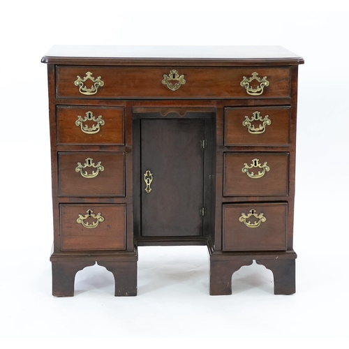 210 - A George III mahogany kneehole desk, fitted six drawers around a central recessed cupboard, on brack... 