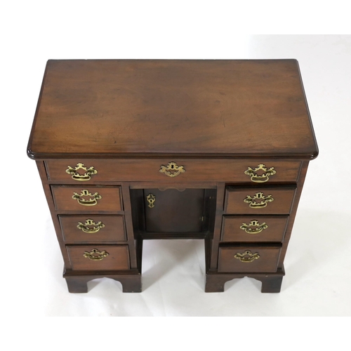 210 - A George III mahogany kneehole desk, fitted six drawers around a central recessed cupboard, on brack... 