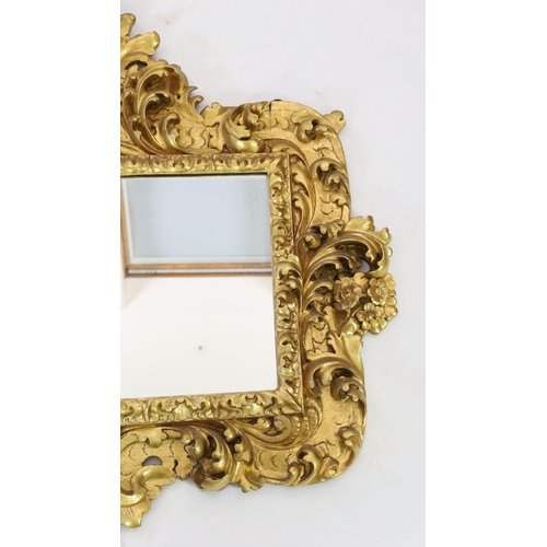 227 - A mid 19th century Florentine ornately carved giltwood wall mirror, of rectangular cartouche form wi... 