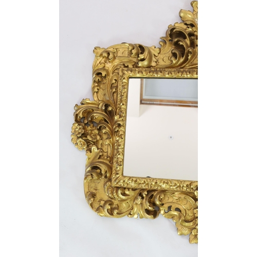 227 - A mid 19th century Florentine ornately carved giltwood wall mirror, of rectangular cartouche form wi... 