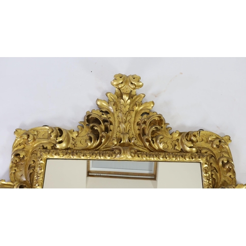 227 - A mid 19th century Florentine ornately carved giltwood wall mirror, of rectangular cartouche form wi... 