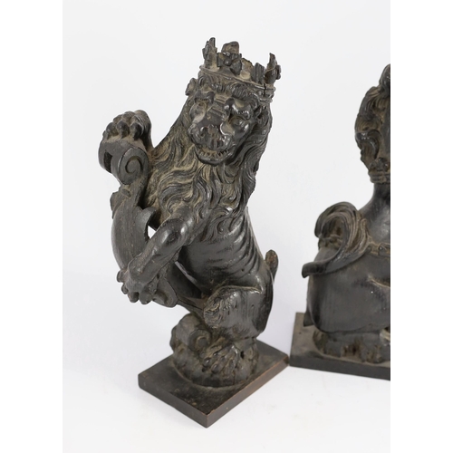 25 - A pair of 18th century carved and ebonised oak heraldic beasts, lion and unicorn, each holding scrol... 