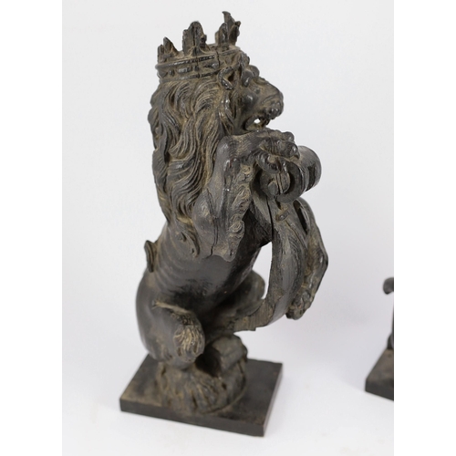 25 - A pair of 18th century carved and ebonised oak heraldic beasts, lion and unicorn, each holding scrol... 