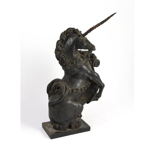 25 - A pair of 18th century carved and ebonised oak heraldic beasts, lion and unicorn, each holding scrol... 