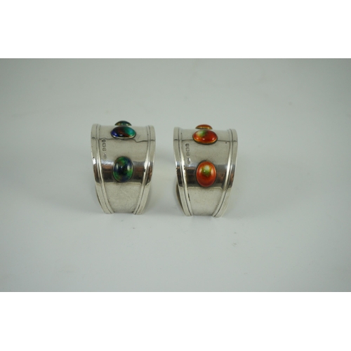 358 - Two similar Edwardian Arts & Crafts silver and enamelled napkin rings, each set with three cabochon ... 