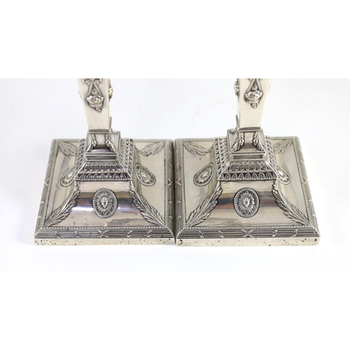 362 - An ornate pair of late Victorian silver candlesticks by Mappin Bros., with waisted square columns an... 