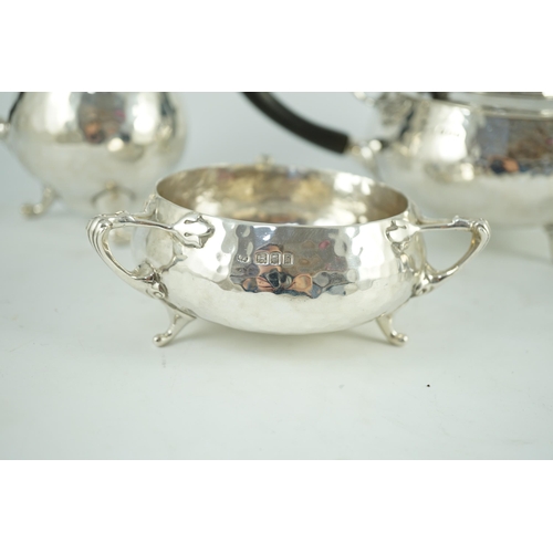 367 - A George V Arts and Crafts three piece planished silver tea set  and a similar hot water pot, by Cha... 