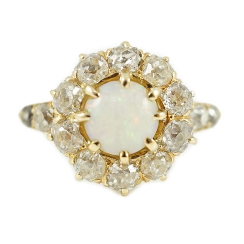 414 - An early 20th century gold, white opal and diamond set circular cluster ring, with graduated diamond... 