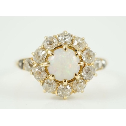 414 - An early 20th century gold, white opal and diamond set circular cluster ring, with graduated diamond... 