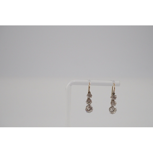 422 - A pair of early to mid 20th century gold, platinum and graduated three stone diamond set drop earrin... 