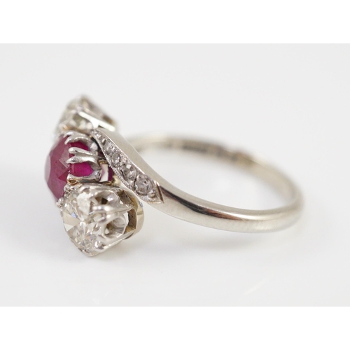 432 - An 18ct white gold and platinum, two stone diamond and single stone synthetic? ruby set crossover ri... 