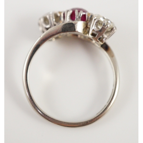 432 - An 18ct white gold and platinum, two stone diamond and single stone synthetic? ruby set crossover ri... 