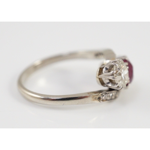 432 - An 18ct white gold and platinum, two stone diamond and single stone synthetic? ruby set crossover ri... 