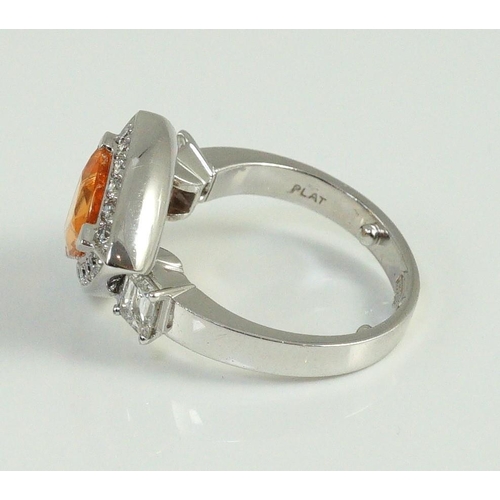 448 - A modern platinum and single stone trilliant cut spessartite garnet ring, with diamond set border an... 