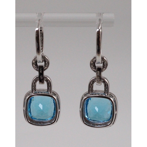 449 - A modern pair of 14kt white gold, blue topaz and diamond chip set drop earrings, each topaz weighing... 