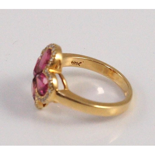 451 - A modern 18k gold four stone pear shaped pink tourmaline set dress ring with diamond chip set border... 