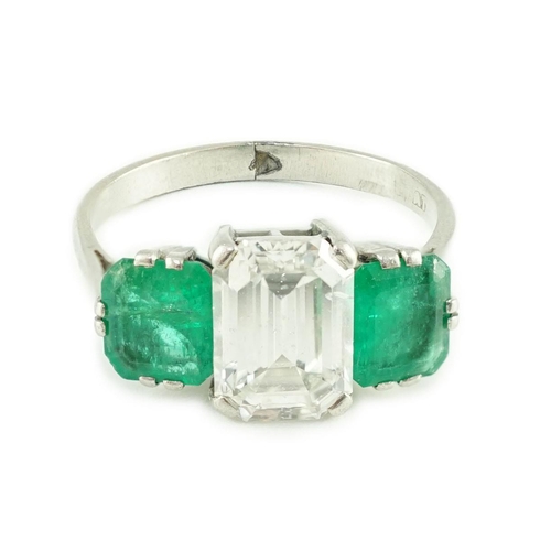 456 - A mid 20th century platinum, single stone emerald cut diamond and two stone emerald set dress ring, ... 