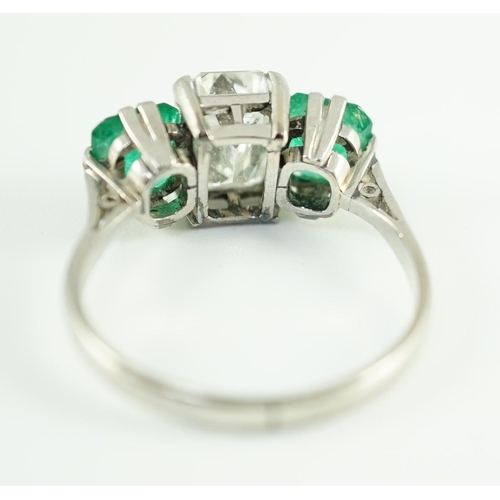 456 - A mid 20th century platinum, single stone emerald cut diamond and two stone emerald set dress ring, ... 