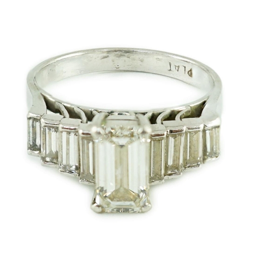 457 - A modern platinum and emerald cut single stone diamond ring, with stepped graduated baguette cut dia... 