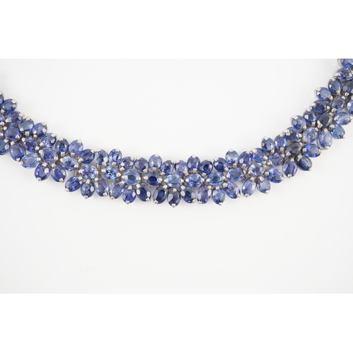 465 - An 18K white gold and synthetic sapphire? flower head cluster set necklace, gross weight 65 grams.... 