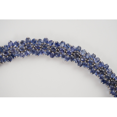 465 - An 18K white gold and synthetic sapphire? flower head cluster set necklace, gross weight 65 grams.... 