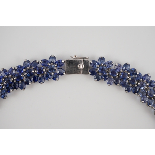 465 - An 18K white gold and synthetic sapphire? flower head cluster set necklace, gross weight 65 grams.... 