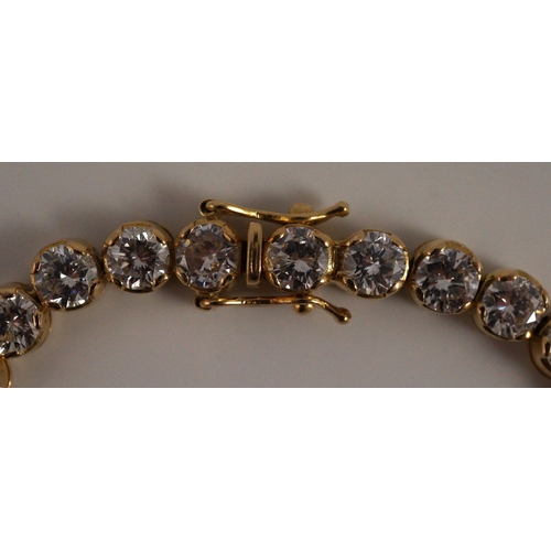 470 - A modern 18k gold and round brilliant cut diamond set line bracelet, set with thirty five stones, ea... 