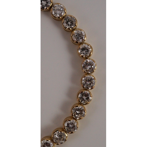 470 - A modern 18k gold and round brilliant cut diamond set line bracelet, set with thirty five stones, ea... 