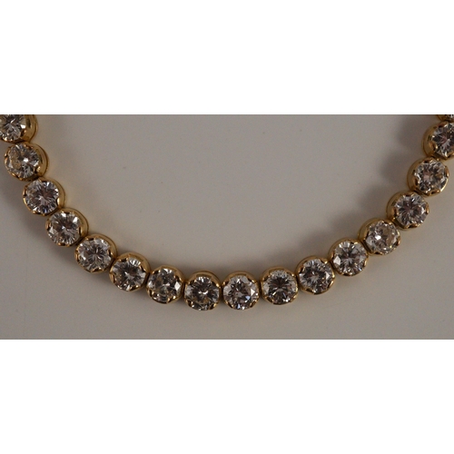 470 - A modern 18k gold and round brilliant cut diamond set line bracelet, set with thirty five stones, ea... 