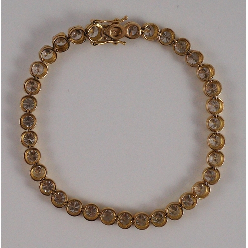 470 - A modern 18k gold and round brilliant cut diamond set line bracelet, set with thirty five stones, ea... 