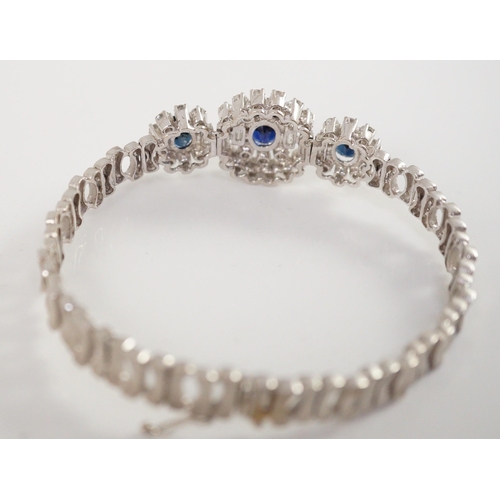 485 - A mid to late 20th century textured 18k white gold, sapphire, round and baguette cut diamond set tri... 