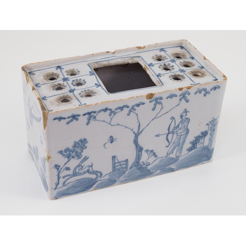 80 - An English delftware flower brick, mid 18th century, painted with Chinese figures in European landsc... 