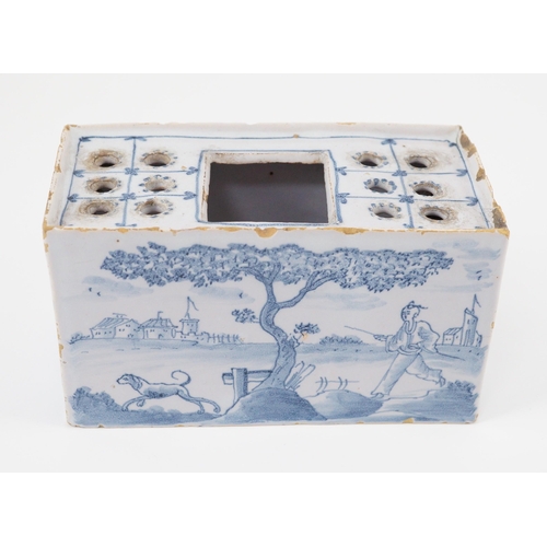 80 - An English delftware flower brick, mid 18th century, painted with Chinese figures in European landsc... 