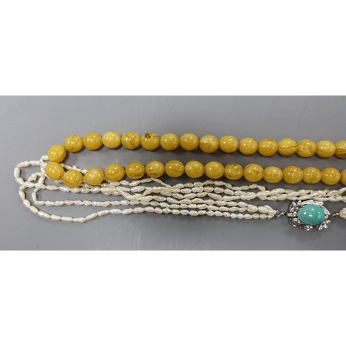 2976 - A multi-strand 'rice pearl' necklace with 18k white metal and turquoise set clasp, 66cm and an amber... 