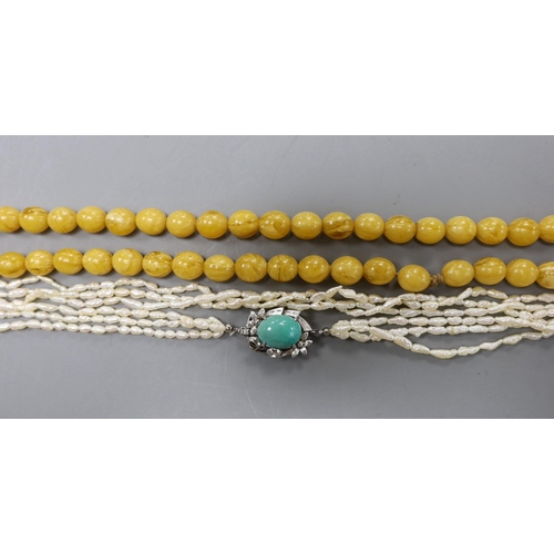 2976 - A multi-strand 'rice pearl' necklace with 18k white metal and turquoise set clasp, 66cm and an amber... 