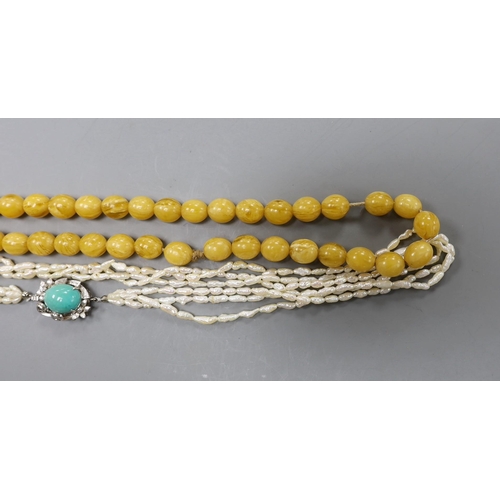 2976 - A multi-strand 'rice pearl' necklace with 18k white metal and turquoise set clasp, 66cm and an amber... 