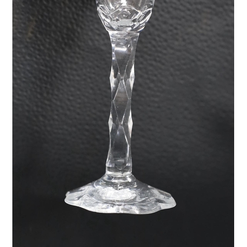 479 - An 18th century facet stemmed glass with a petal foot,16.5 cms high,