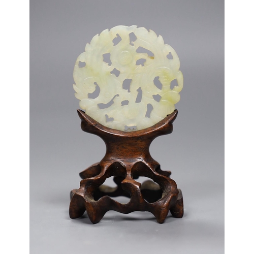 529 - A Chinese jade disc and wood stand,9cms high,