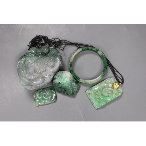 540 - A group of five Chinese jadeite carvings, including two pendants and a bangle, largest 11cms long,... 