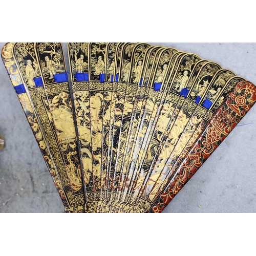 552 - A Chinese gilt-decorated lacquer fan in a brocade covered case, 19th century