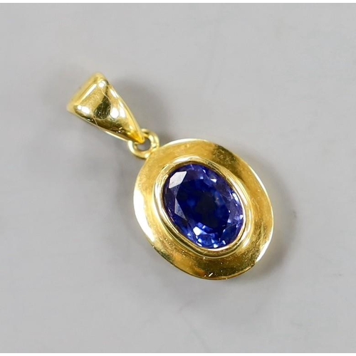 884 - A modern 18k and oval cut sapphire set pendant, overall 22mm, gross weight 3.1 grams.