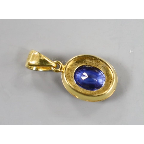 884 - A modern 18k and oval cut sapphire set pendant, overall 22mm, gross weight 3.1 grams.