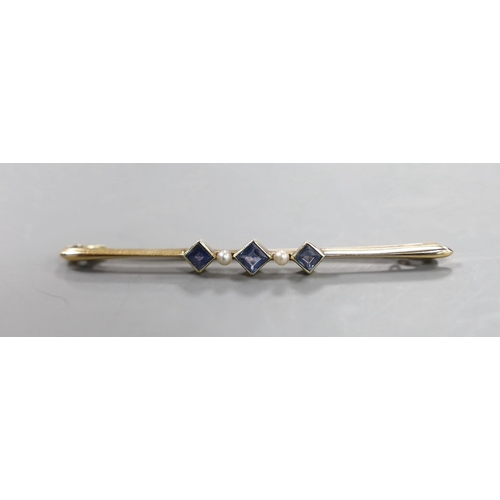 902 - An Edwardian 15ct, three stone sapphire and two stone seed pearl set bar brooch, 57mm, gross 3.4 gra... 