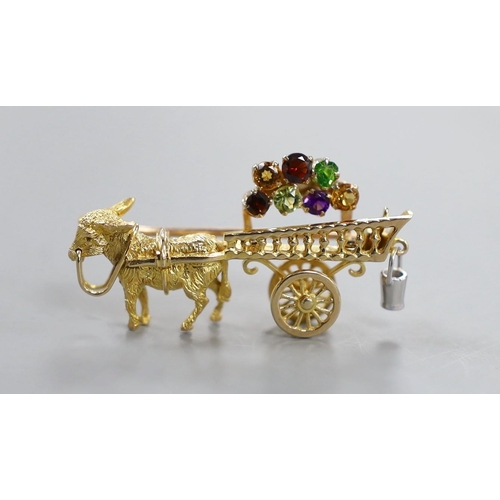 938 - A modern yellow metal hinged bangle with Greek Key decoration and a 9ct donkey and cart charm, gross... 