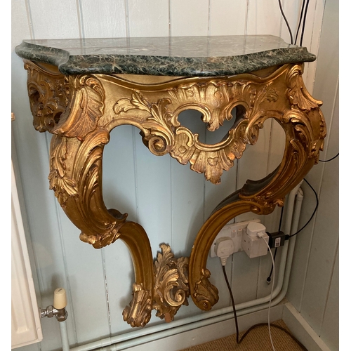 131 - A pair of 18th century style carved giltwood serpentine console tables with variegate green marble t... 