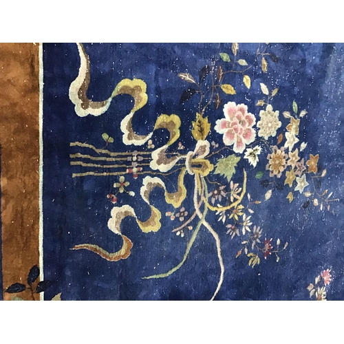 1017 - An early 20th century Chinese blue ground carpet woven with butterflies and flowering branches 450cm... 