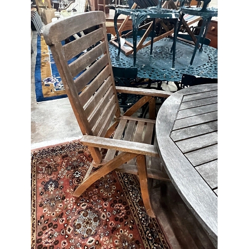 1053 - A circular weathered teak folding garden table and four teak folding armchairs, stamped Royal Craft,... 