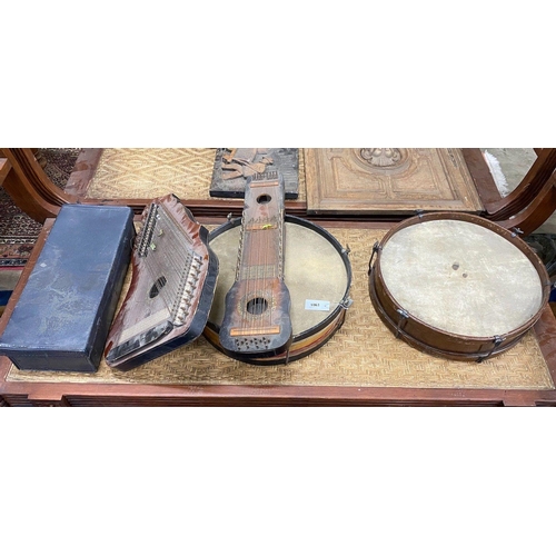 1063 - A group of assorted musical instruments comprising two large tambourines, two zithers and a Zenith t... 