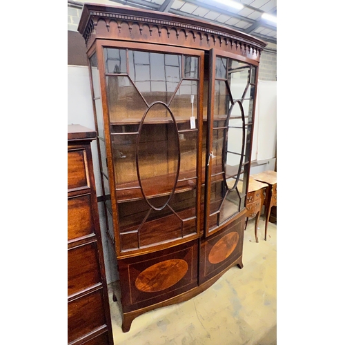 1010 - An early 20th century George III style satinwood banded mahogany inlaid bow front display cabinet, w... 